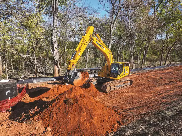 Operator Jesus Collazo digs a trench with a Komatsu PC290LCi-11 Intelligent Machine Control (IMC) excavator on a road widening project near Pawnee, Okla. 