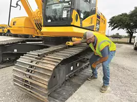 KSM PSSR Marc Owens checks track tension with a straight edge and a ruler. 