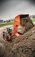 New Loader dumping dirt under cloudy sky