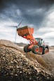 New Hitachi Loader in field under cloudy sky